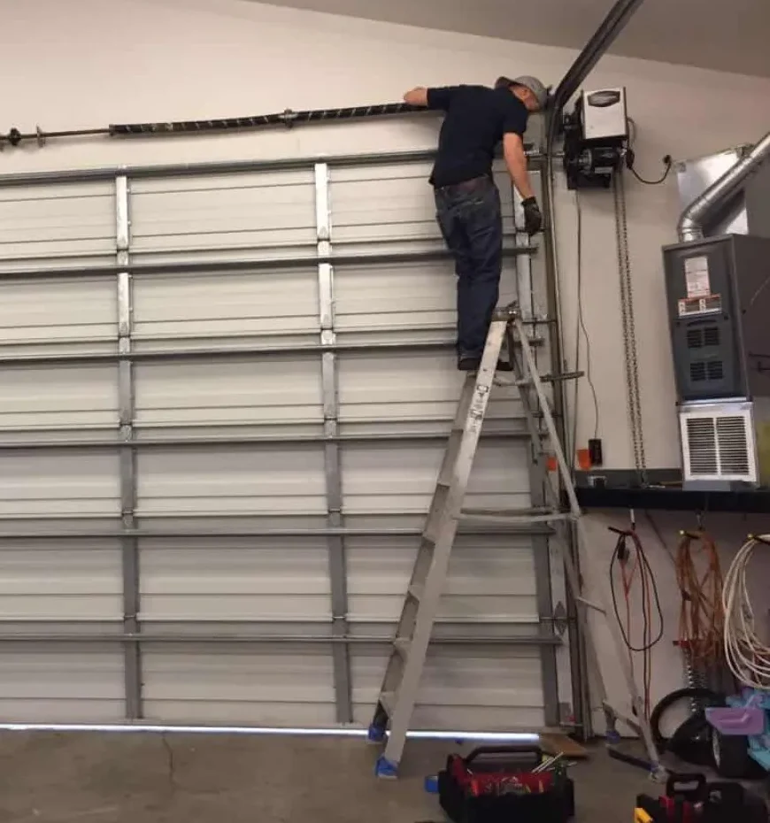 fixing garage door safety sensor issues Las Vegas technician working